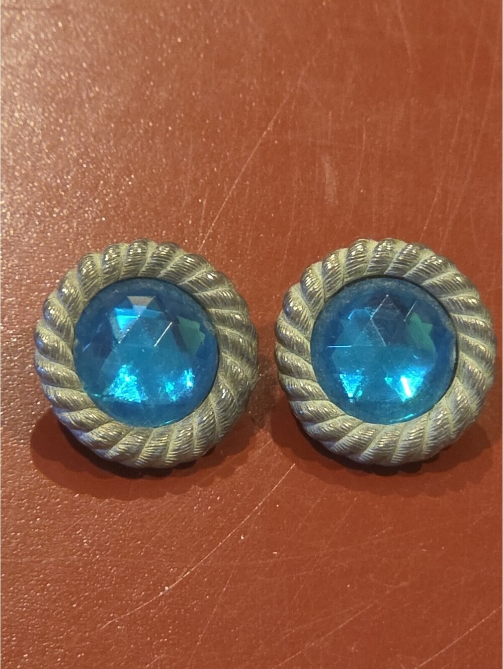 Clip On vintag earrings feature blue faceted stones set within a textured...